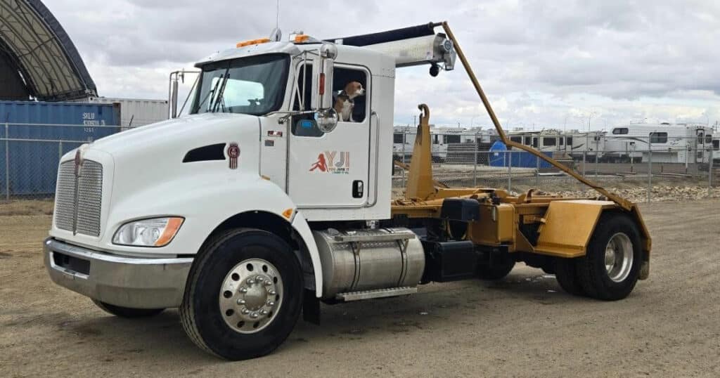 YJI Truck with dog in the drivers seat parked at a construction site