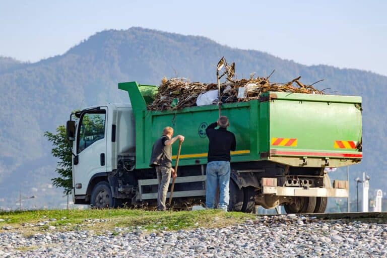 Dump truck collecting yard debris and waste for recycling or disposal.