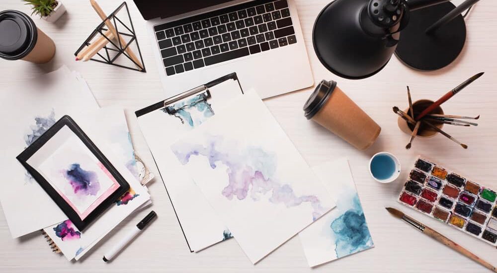 Messy office desk with sketches and empty coffee cups