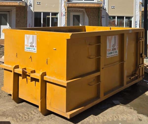 Heavy-duty construction dumpster for debris removal at building site.