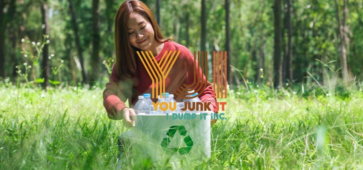 a woman sitting in a grassy area with a recycle sign