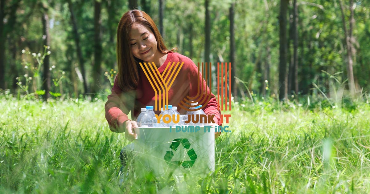 a woman sitting in a grassy area with a recycle sign