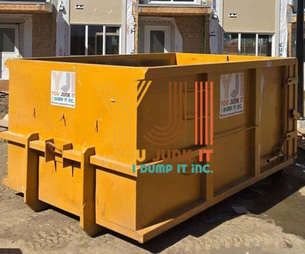 Large yellow construction dumpster at a building site, ready for debris disposal, with You Junk It… I Dump It branding, ideal for commercial or residential waste removal services.