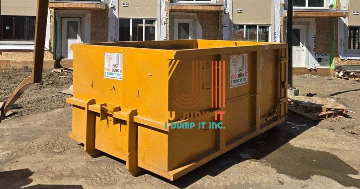 Large yellow construction dumpster at a building site, ready for debris disposal, with You Junk It… I Dump It branding, ideal for commercial or residential waste removal services.