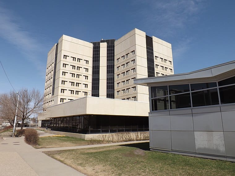 Modern office building with a sleek architectural design, large windows, and a landscaped outdoor area.