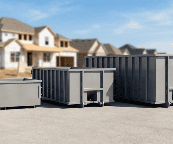 Waste disposal containers for construction debris on a paved surface in a suburban area.